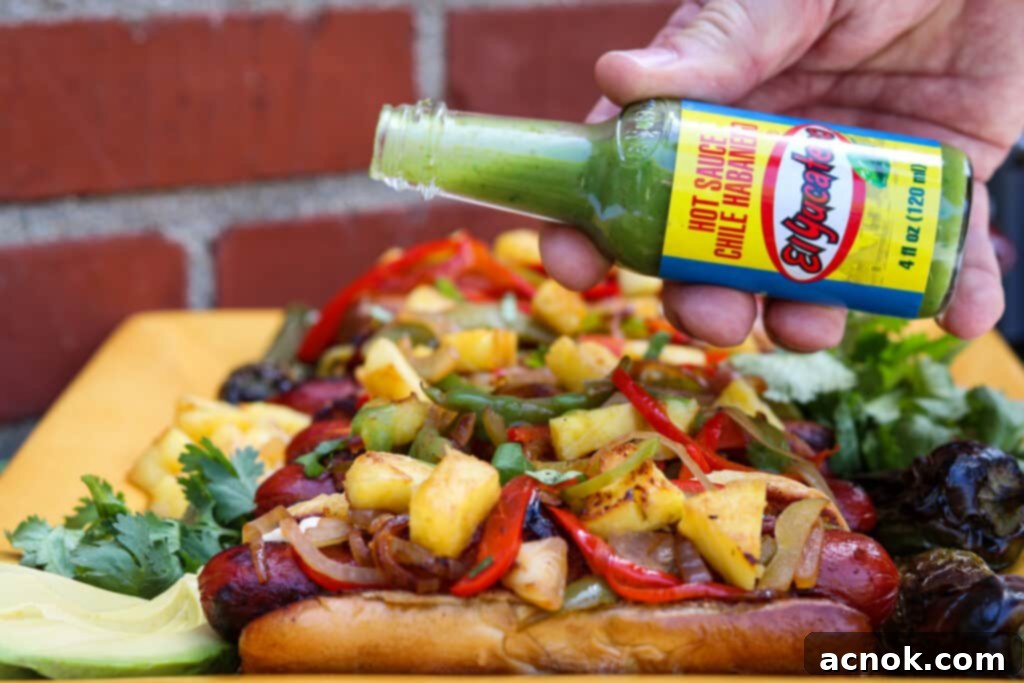 LA style street hot dogs with a bottle of El Yucateco hot sauce nearby, emphasizing the flavor.