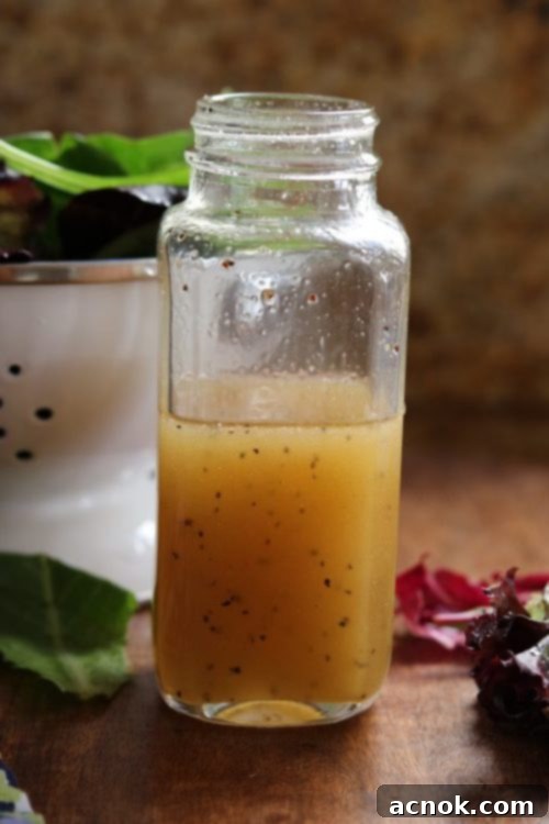 Ready-to-serve Maple Vinaigrette Dressing in a glass jar with fresh herbs