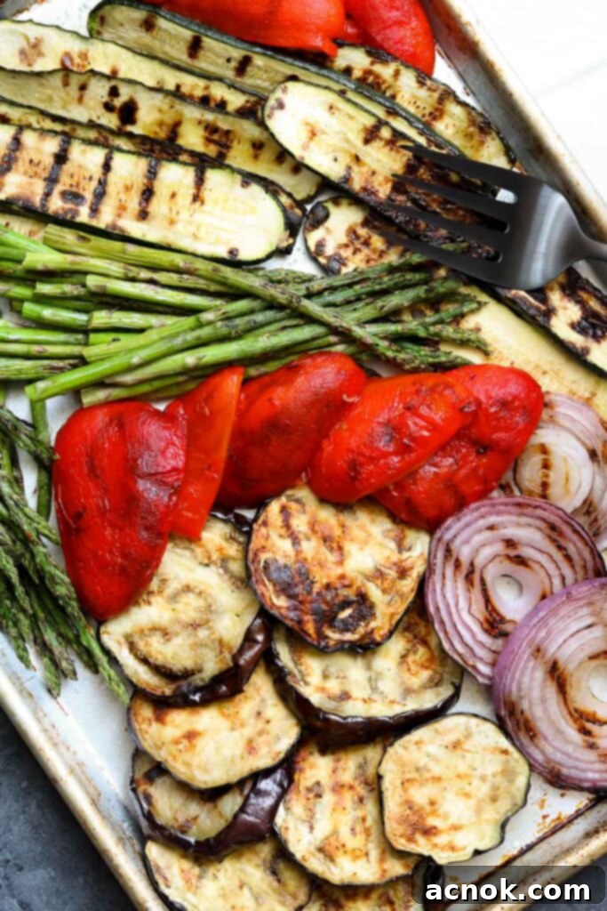 grilled balsamic vegetables on sheet pan with serving fork