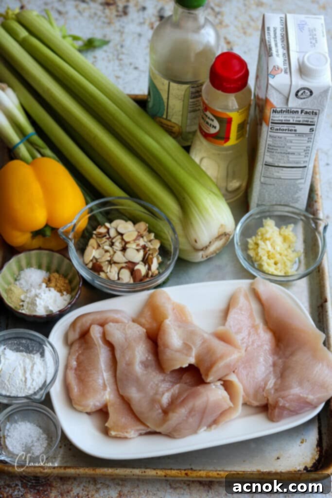 A flat lay photograph showcasing all the fresh and prepared ingredients for an easy almond chicken stir fry recipe.