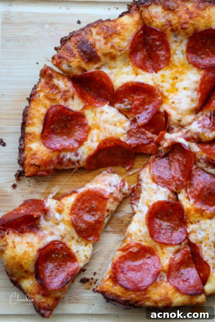 cast iron pan pizza sliced into wedges on cutting board 