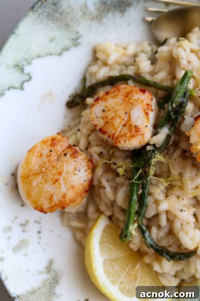close up of creamy risotto, scallops, asparagus and lemon