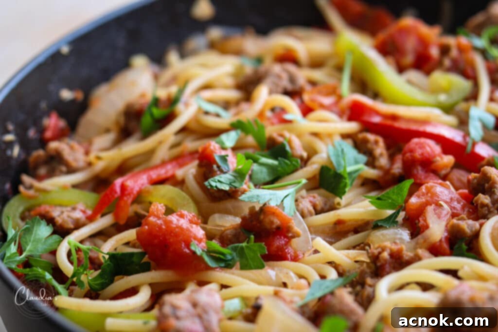 Close-up view of spicy Italian sausage and pepper spaghetti, ready to be served.