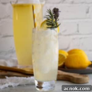 Lavender lemonade in tall glass with ice and garnishes