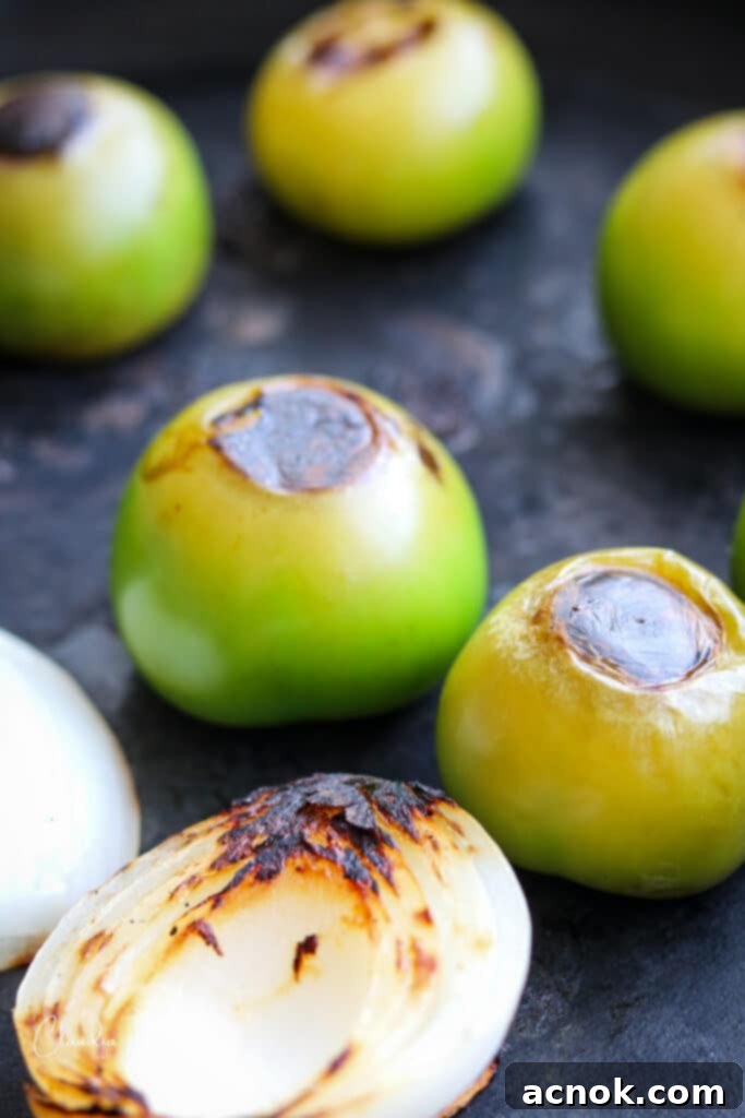 close up of tomatillos roasting in the cast iron pan