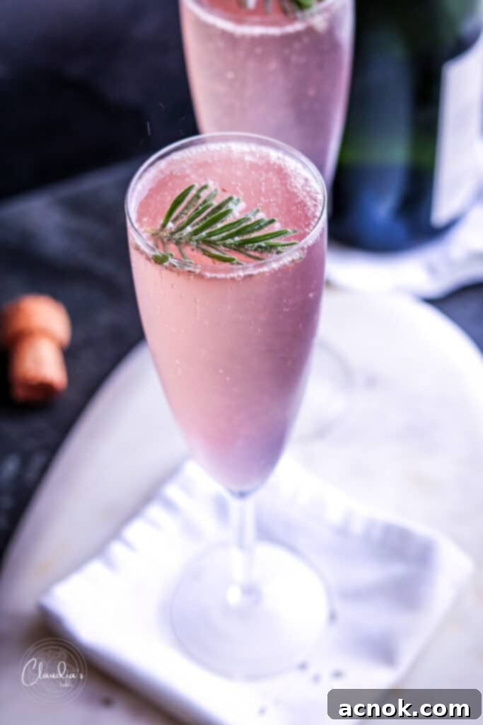 Close-up of Lavender French 75 cocktail with fresh lavender sprigs and lemon twist