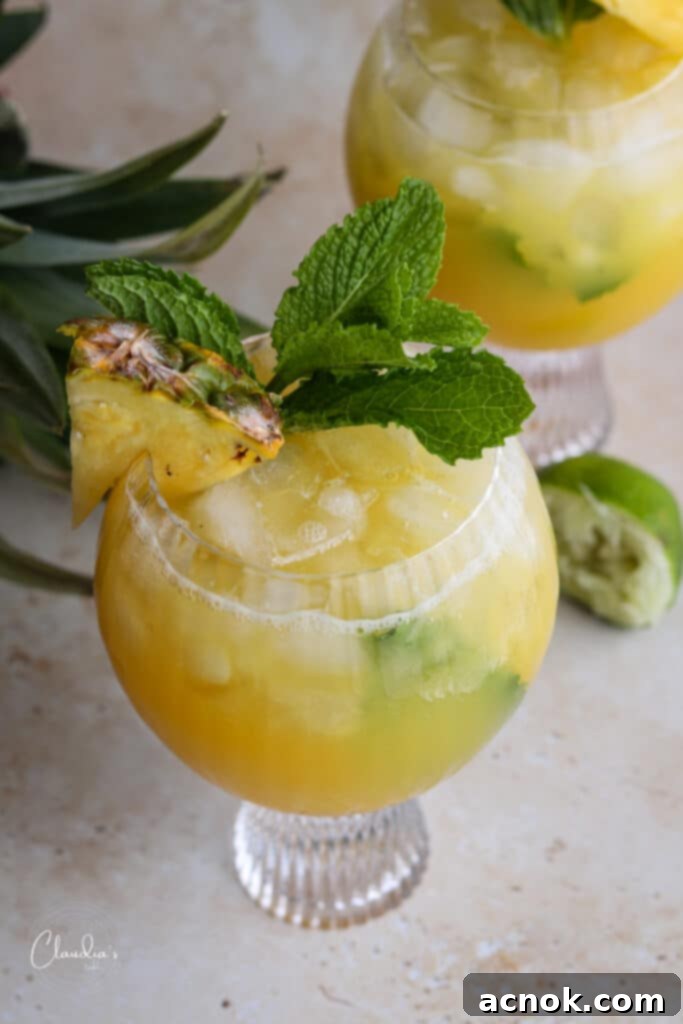 healthy tropical mocktail with fresh mint and pineapple wedge