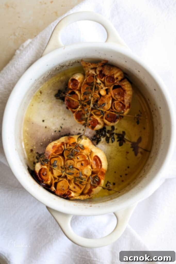 Perfectly roasted garlic head in a ceramic cocotte, golden brown and soft