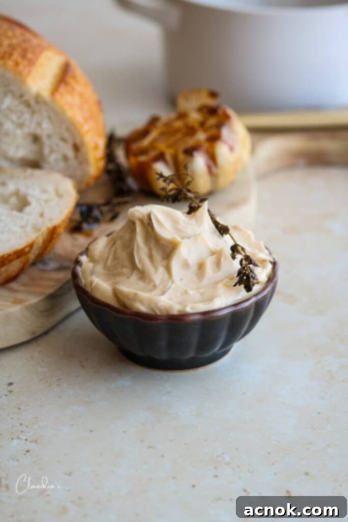 Roasted garlic compound butter served with roasted garlic cloves and sourdough bread slices