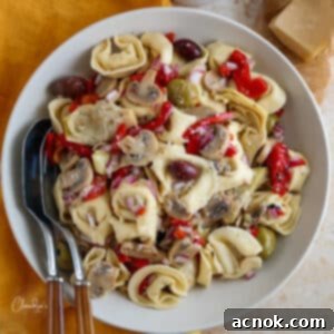 tortellini pasta salad in large bowl with yellow napkin