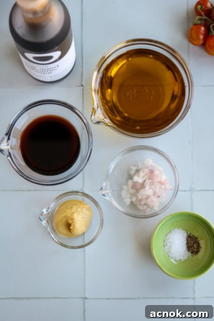 Fresh ingredients for homemade balsamic vinaigrette, including balsamic vinegar, olive oil, shallots, and Dijon mustard.