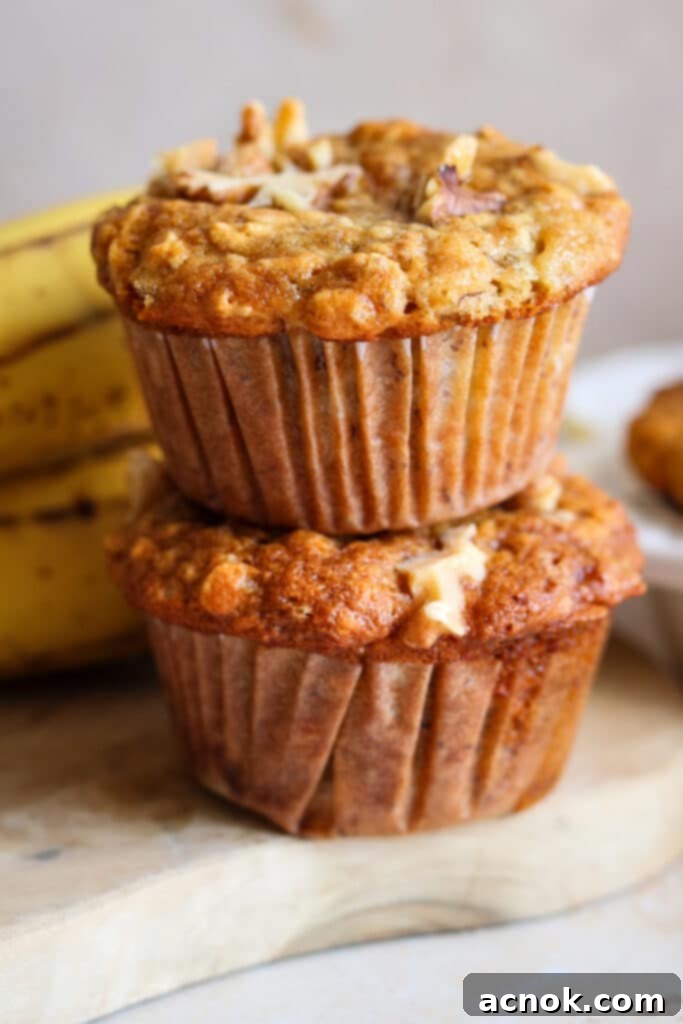 Stack of freshly baked banana and oat muffins, golden brown and inviting.