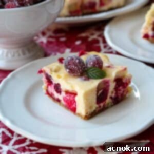 Square image of Cranberry Orange Cheesecake Bars garnished with sugared cranberries, ready to be served.