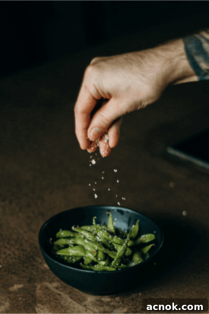 sprinkling salt on edamame 