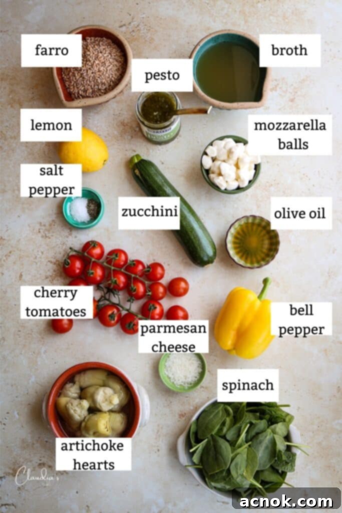 Ingredients laid out for a Farro Salad with Pesto, including fresh vegetables, farro, and cheese.