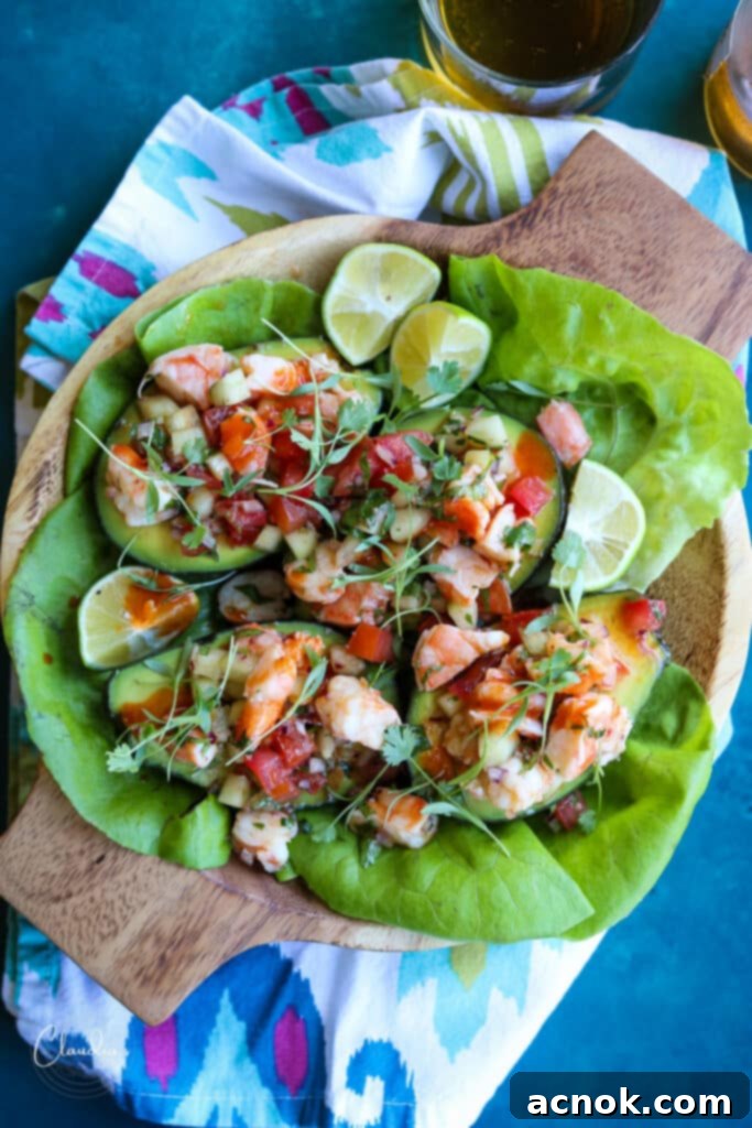 Shrimp avocado salad boats served with butter lettuce, lime wedges, and hot sauce on a large platter.