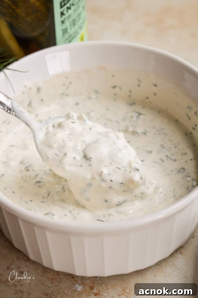 spicy dill pickle ranch dressing in white bowl with spoon