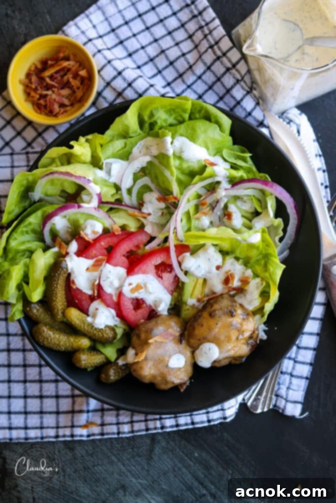 quick cheeseburger salad bowl with bacon in a black bowl.