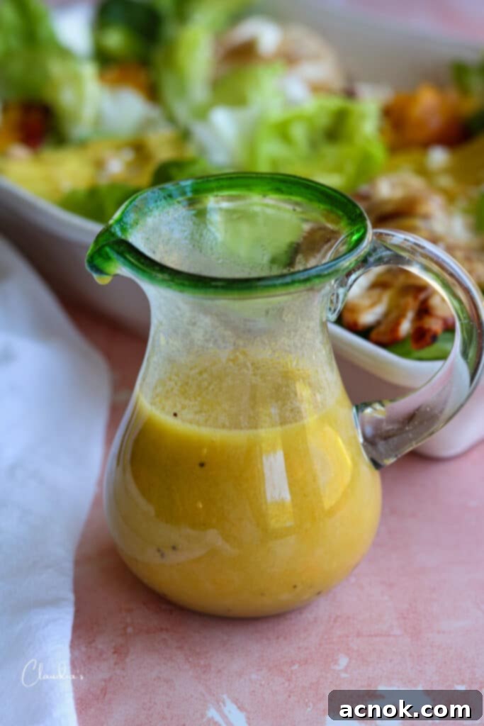 fresh peach salad dressing in small pitcher next to salad 