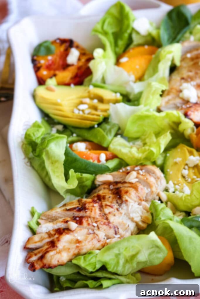 Close up of grilled peach avocado chicken salad showing grilled chicken and peaches