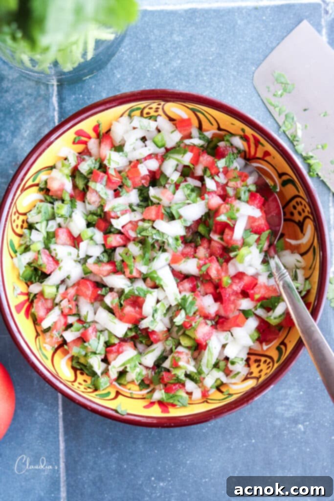 Freshly made pico de gallo in a colorful ceramic bowl, ready to serve with a spoon