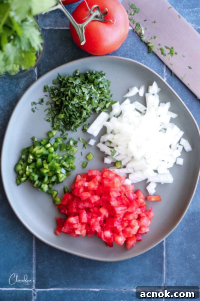 Close-up of fresh pico de gallo ingredients uniformly chopped and arranged on a cutting board