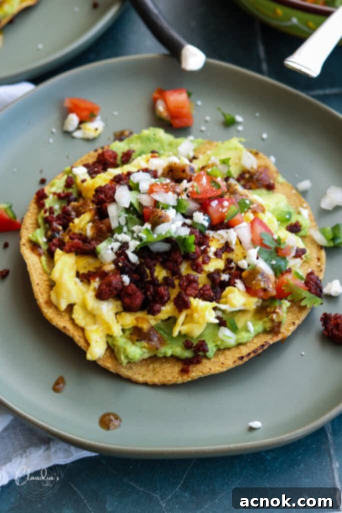 Breakfast tostada with avocado, eggs, and chorizo atop of crispy tostada shell.