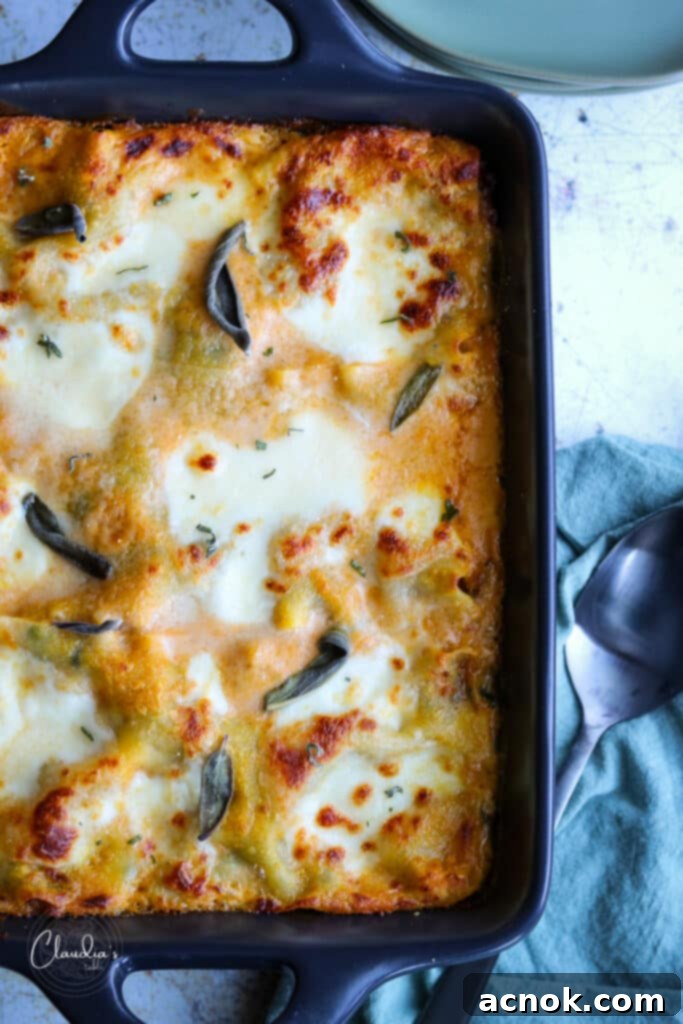 Savory Autumn Lasagna: Pumpkin, Sausage & Kale Delight 2 Pumpkin lasagna with sausage and kale in a black dish with sage.